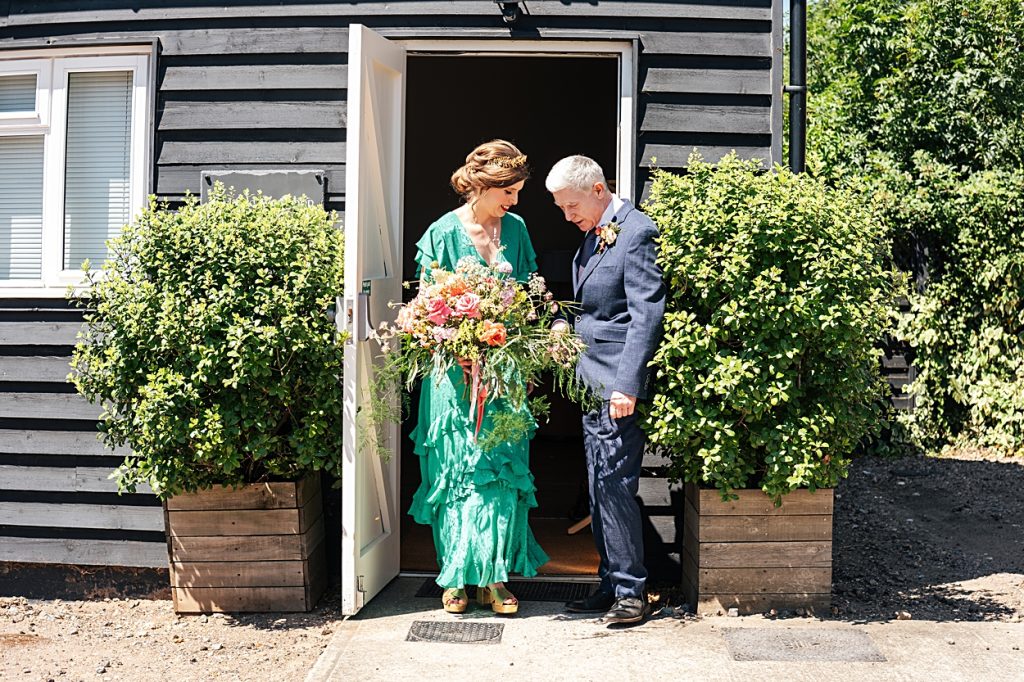 Multi coloured Summer wedding with a bride wearing green at The Barns at Lodge Farm. Essex documentary wedding photographer