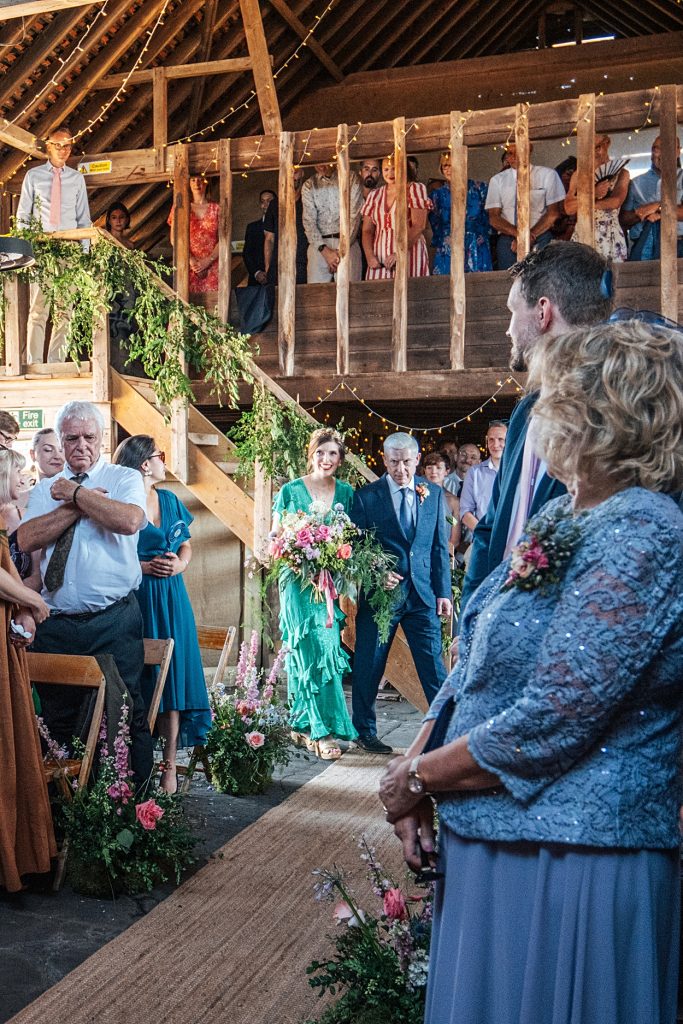 Multi coloured Summer wedding with a bride wearing green at The Barns at Lodge Farm. Essex documentary wedding photographer