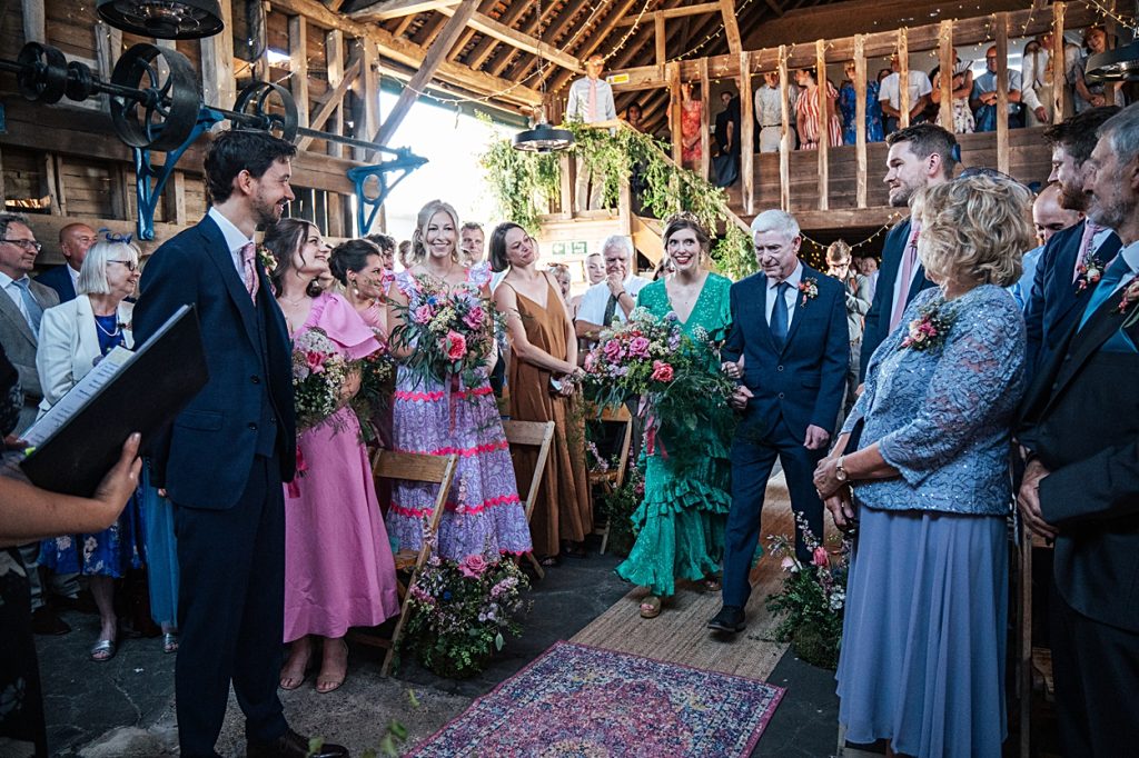 Multi coloured Summer wedding with a bride wearing green at The Barns at Lodge Farm. Essex documentary wedding photographer