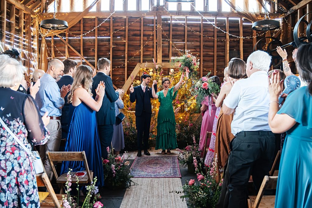 Multi coloured Summer wedding with a bride wearing green at The Barns at Lodge Farm. Essex documentary wedding photographer
