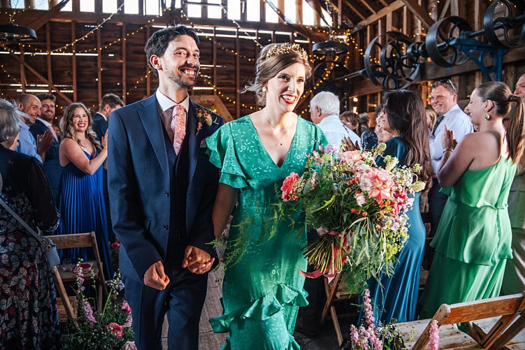 Multi coloured Summer wedding with a bride wearing green at The Barns at Lodge Farm. Essex documentary wedding photographer