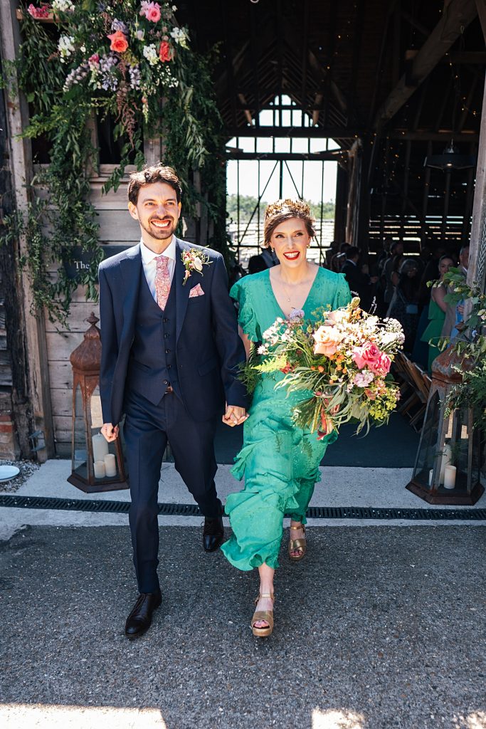 Multi coloured Summer wedding with a bride wearing green at The Barns at Lodge Farm. Essex documentary wedding photographer