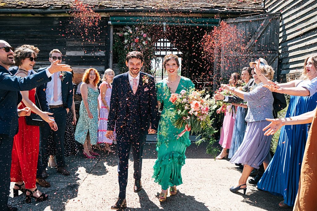 Multi coloured Summer wedding with a bride wearing green at The Barns at Lodge Farm. Essex documentary wedding photographer