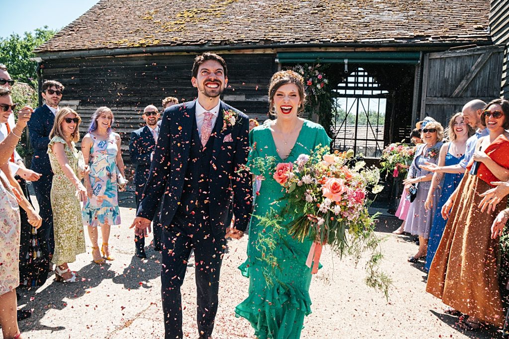 Multi coloured Summer wedding with a bride wearing green at The Barns at Lodge Farm. Essex documentary wedding photographer