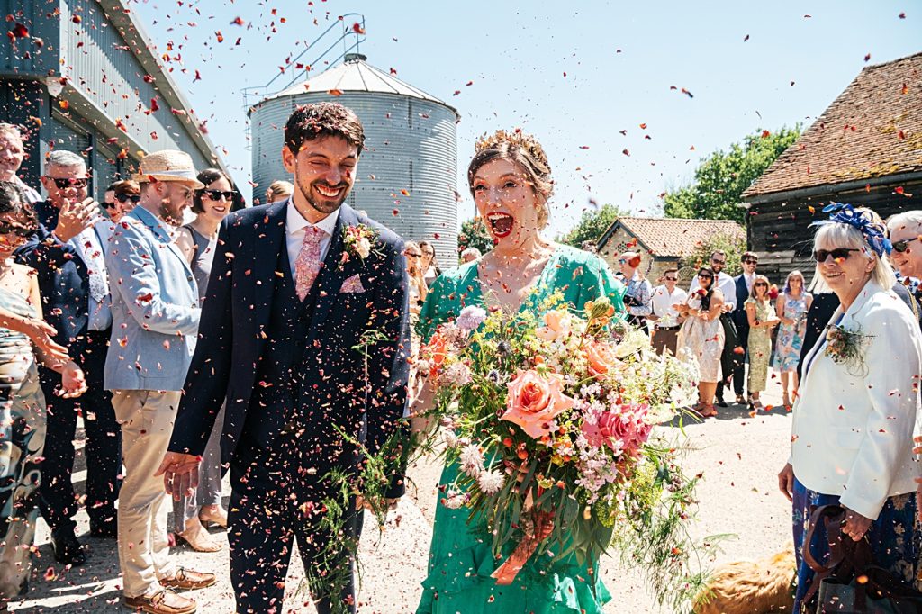 Multi coloured Summer wedding with a bride wearing green at The Barns at Lodge Farm. Essex documentary wedding photographer