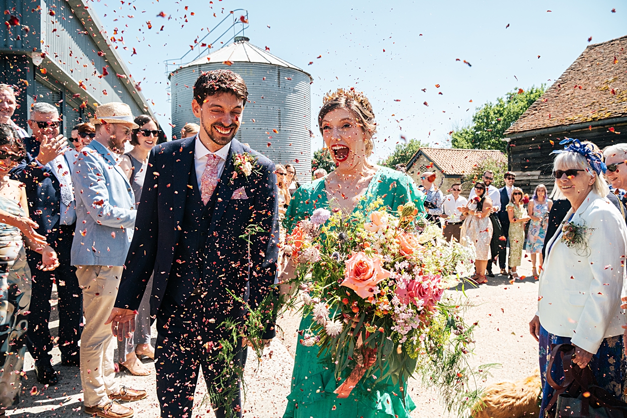 Multi coloured Summer wedding with a bride wearing green at The Barns at Lodge Farm. Essex documentary wedding photographer