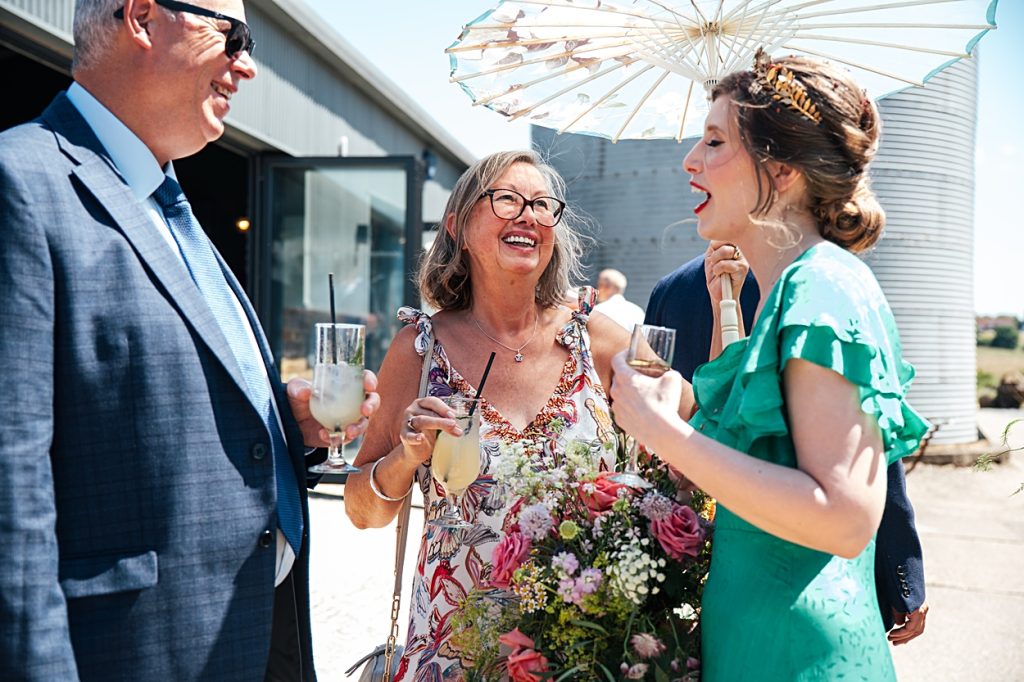 Multi coloured Summer wedding with a bride wearing green at The Barns at Lodge Farm. Essex documentary wedding photographer
