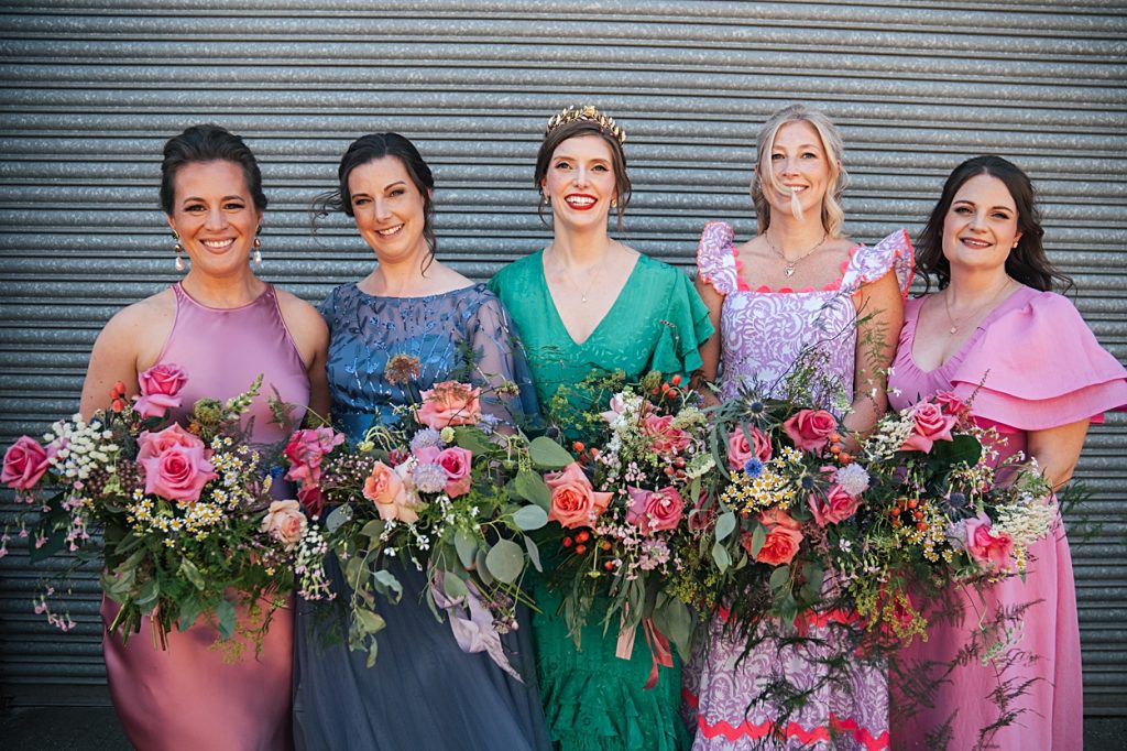 Multi coloured Summer wedding with a bride wearing green at The Barns at Lodge Farm. Essex documentary wedding photographer
