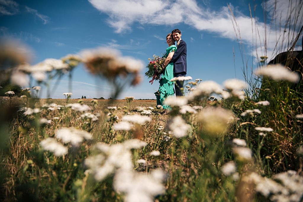 Multi coloured Summer wedding with a bride wearing green at The Barns at Lodge Farm. Essex documentary wedding photographer