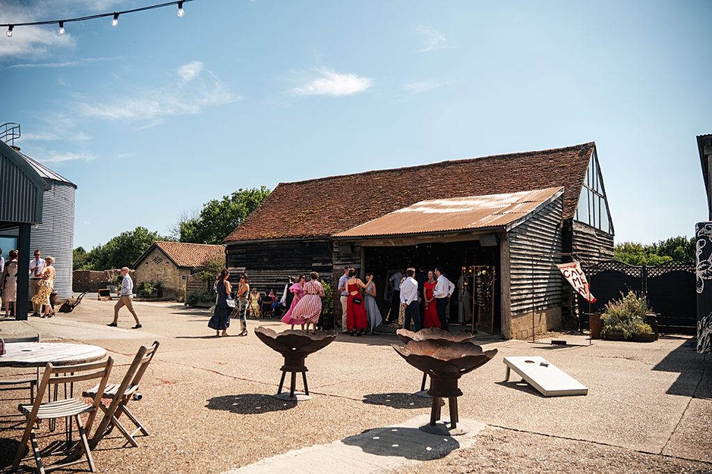 Multi coloured Summer wedding with a bride wearing green at The Barns at Lodge Farm. Essex documentary wedding photographer